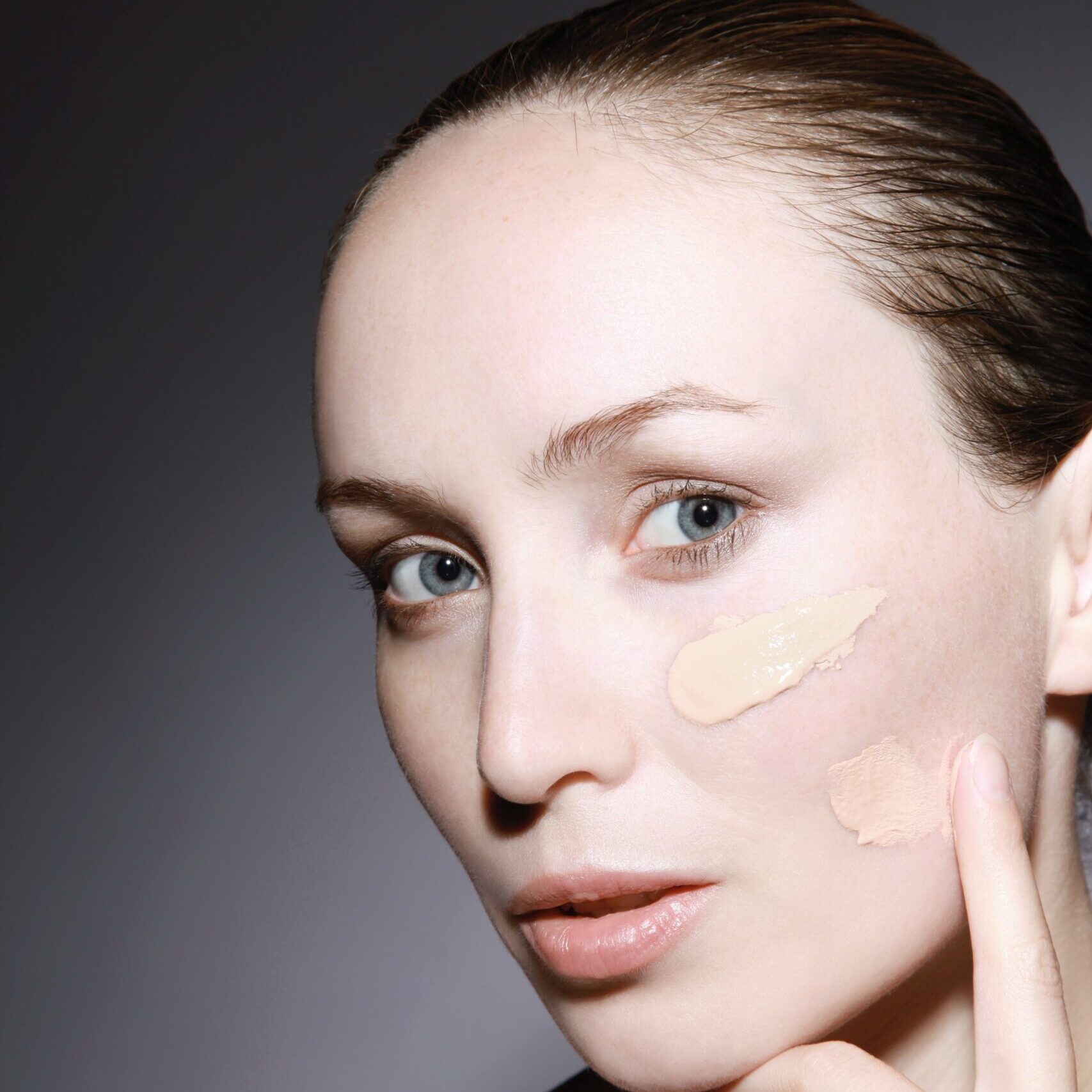 woman applying cream on face