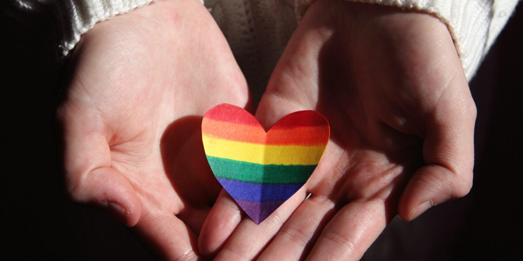 pexels-sharon-mccutcheon-3738057 handis hoding a PRIDE coloured heart