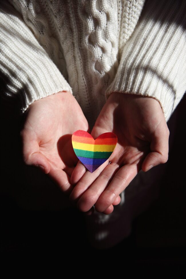 pexels-sharon-mccutcheon-3738057 handis hoding a PRIDE coloured heart