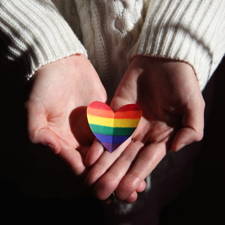 handis hoding a PRIDE coloured heart
